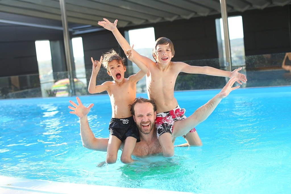 family swimming in pool